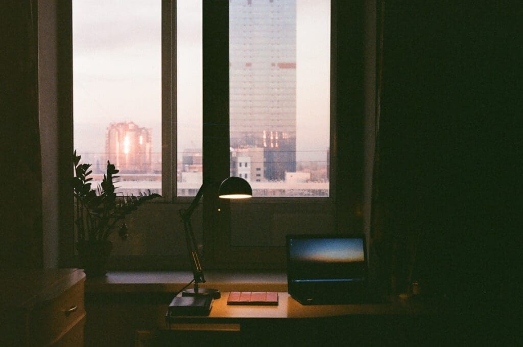 Desk with laptop still open late in the evening, illustrating professional burnout